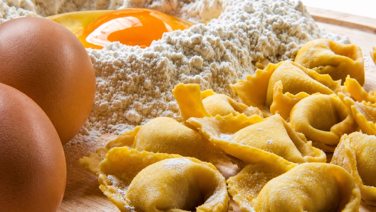 Ingredienti e pasta fresca su piano di lavoro